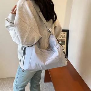 Light purple canvas tote bag with letter embroidery and bow decoration on model