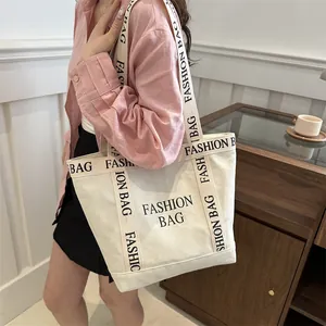 Minimalist canvas tote bag with black Fashion Bag print worn by a model in a warm interior