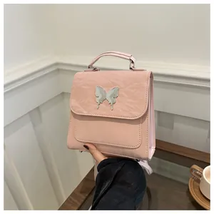 Detailed view of pink pleated PU backpack with silver butterfly metal ornament