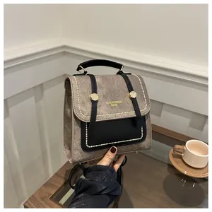 Gros plan du sac à dos vintage taupe avec lettrage doré et coutures beiges détaillées