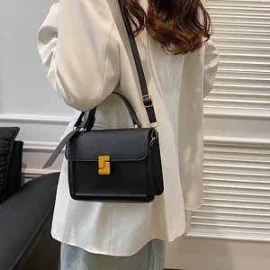 Minimalist black PU leather crossbody bag with a unique gold geometric S-buckle