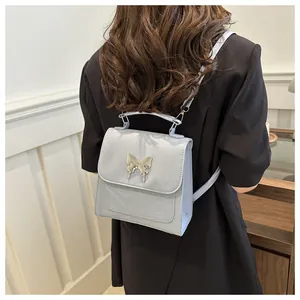 Detail of light blue glossy leather backpack featuring a liquid metal butterfly buckle