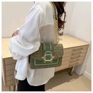 Détail du sac bandoulière en tweed vert avec broderie blanche et chaîne dorée