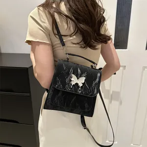 Black textured leather backpack for women with silver butterfly detail and adjustable straps