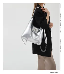 Close-up of silver PU leather tote bag with metallic bow buckle and chain detail