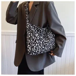Detail view of large leopard print canvas tote bag styled with a grey blazer outfit