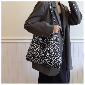 Detailed view of the wide shoulder strap on this black and white leopard print canvas tote