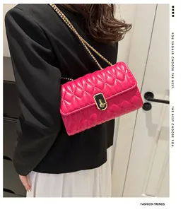 Close-up of rose red quilted heart-pattern bag with gold chain and elegant lock