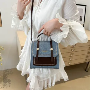 Sac à main rétro en denim bleu et cuir marron avec rivets dorés et bandoulière