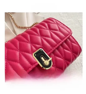 Detailed macro view of the fuchsia quilted leather bag with a gold clasp and metal chain