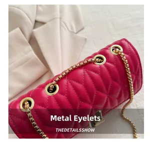 Detail of fuchsia quilted handbag with gold metal eyelets and chain strap