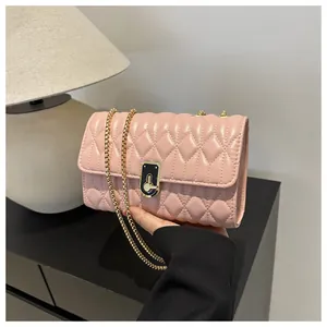Detail of pink quilted leather crossbody bag with elegant gold chain and modern clasp