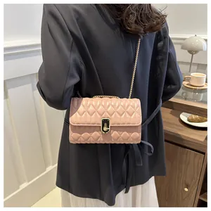 Detailed view of pink quilted leather bag with gold chain strap on a model's back