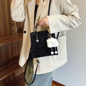 Zwarte crossbodytas met rimpeltextuur, zilveren hardware en pluchen wolk hanger
