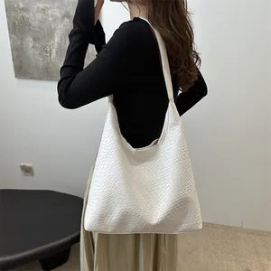 Minimalist white woven tote bag with wide shoulder strap for fashion commute wear