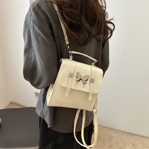Elegant cream leather mini backpack with silver butterfly detail and adjustable straps