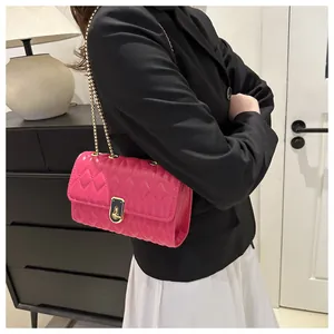 Detail of hot pink quilted crossbody bag with gold chain strap and turn-lock closure