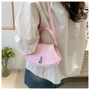 Detail of pink semi-circular handbag with silver lock buckle and shoulder strap