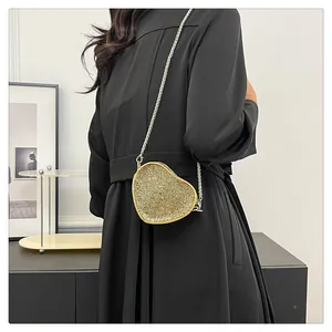 Detailed view of heart-shaped mini bag with sparkling gold rhinestones and silver chain