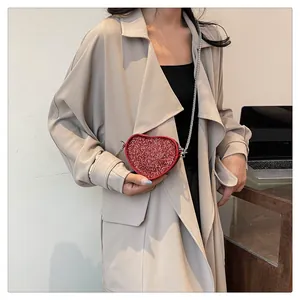 Detail of red sequin heart-shaped mini crossbody bag with silver metal chain strap