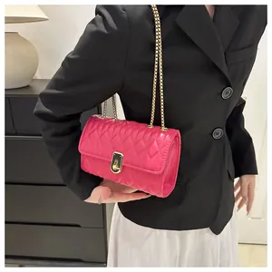 Detail of rose pink quilted crossbody bag with gold metal chain strap and twist lock