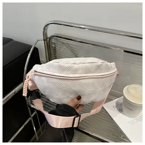 Detail of pink woven texture on crossbody bag with adjustable strap and braided zipper pull