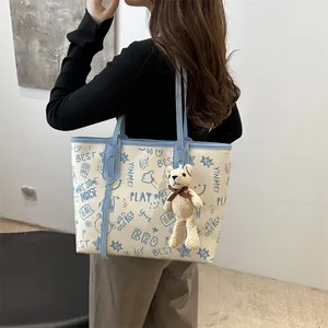 Large capacity graffiti tote bag in cream and light blue with a teddy bear charm