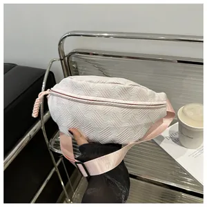 Detail of pink and white woven crossbody bag with adjustable wide nylon shoulder strap