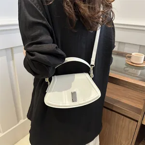 Chic white semi-circular leather handbag with silver metal buckle and crossbody strap