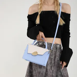 Minimalist light blue and cream crossbody handbag with golden clasp for summer fashion
