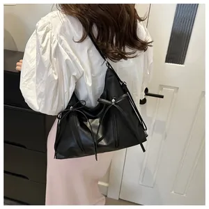 Detailed view of black PU leather hobo bag with bow ties and vertical zipper detail