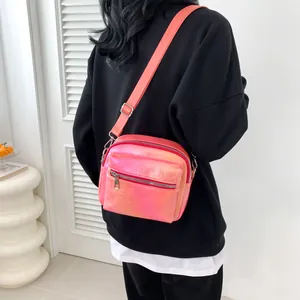 Metallic pink square crossbody bag with adjustable wide strap and front zipper pocket