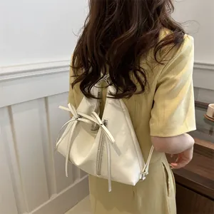 Minimalist beige leather triangle backpack for women with ribbon bow and dual zippers