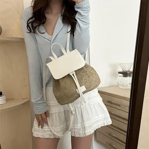 Elegante mini zaino in paglia intrecciata con patta in pelle bianca e chiusura a coulisse