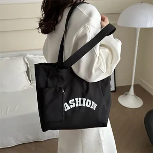 Large black canvas tote bag with wide shoulder strap and matching small zipper pouch