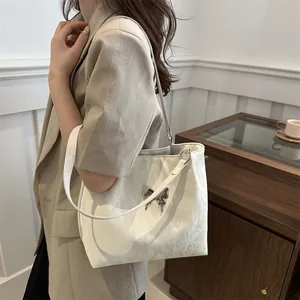 Cream soft leather shoulder bag with metallic butterfly buckle and pleated texture detail