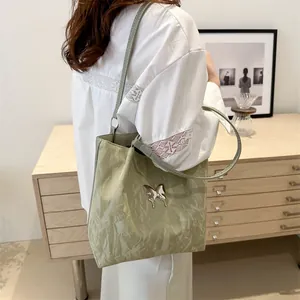 Light green pleated shoulder bag with silver butterfly charm for daily commute style