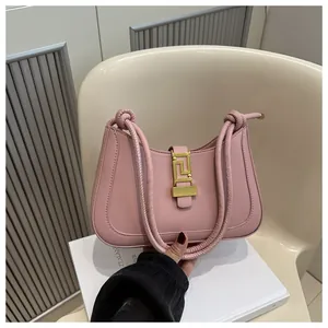Detail of pink vintage shoulder bag with golden geometric buckle and braided straps