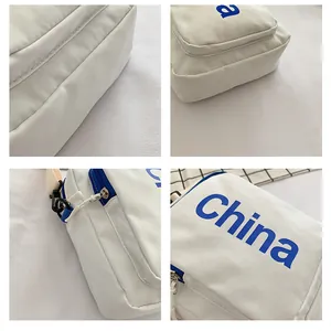 Detailed close-up showing white nylon fabric, blue China print and zipper of the crossbody bag
