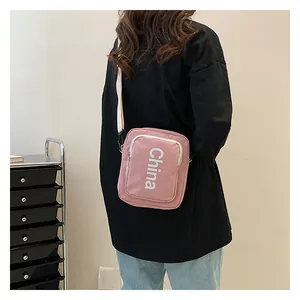 Pink crossbody bag with China print and adjustable strap shown on a female model