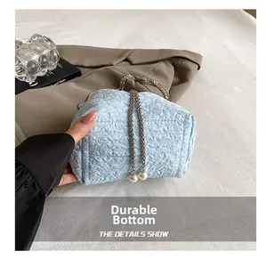 Détail du sac seau bleu clair avec fond résistant à l'usure et chaîne à perles