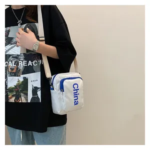 Close-up of a white rectangular crossbody bag with blue China lettering and strap
