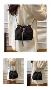 Détail du sac seau noir plissé avec chaîne argentée et cordons ornés de perles