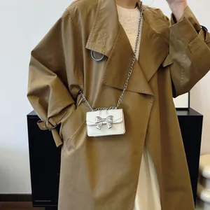 Mini white crossbody bag with silver bow accent and metal chain strap for women