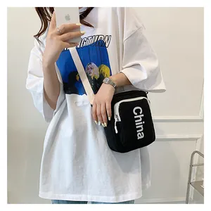 Close-up of black canvas crossbody bag with white China lettering and adjustable strap