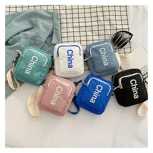 Detailed flat lay of colorful nylon crossbody bags with China lettering in a casual setting