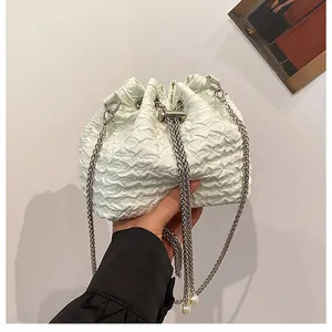 Gros plan du sac seau plissé vert menthe avec bandoulière chaîne argentée et perles