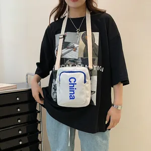 Minimalist white canvas crossbody bag with blue China lettering and adjustable strap