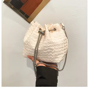 Vue détaillée du sac seau plissé blanc cassé avec cordon de serrage et chaîne argentée