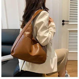 Detail showing dark brown faux leather tote bag with functional side pocket on model